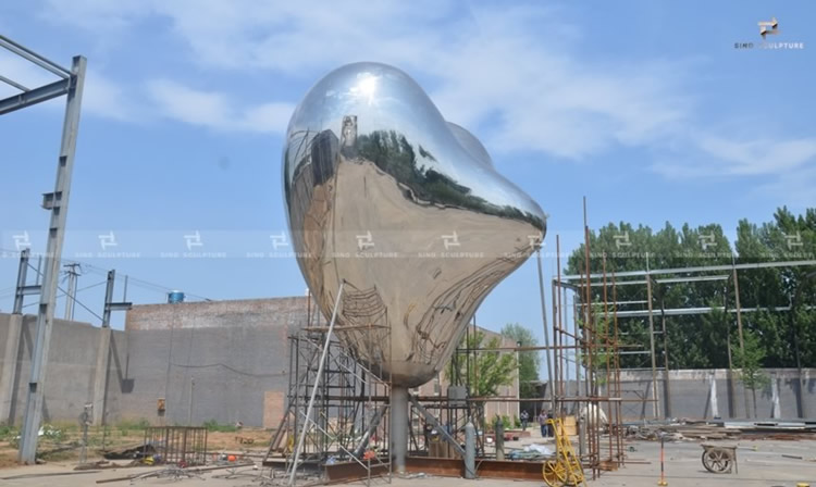 polishing stainless steel sculpture, Love me by Richard hudson