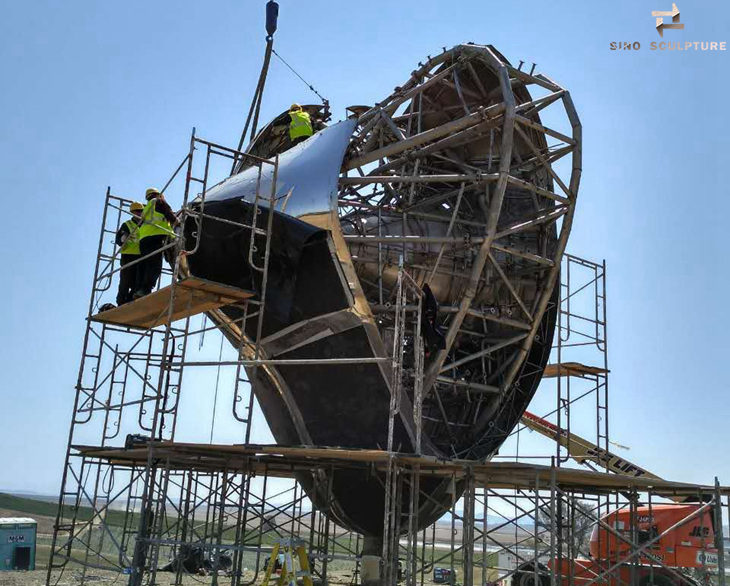 installation of stainless steel love me sculpture