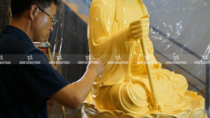 adhesive sizing application on the bronze buddha surface