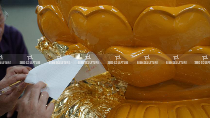 covering the gold leaf on the surface of bronze buddha statue