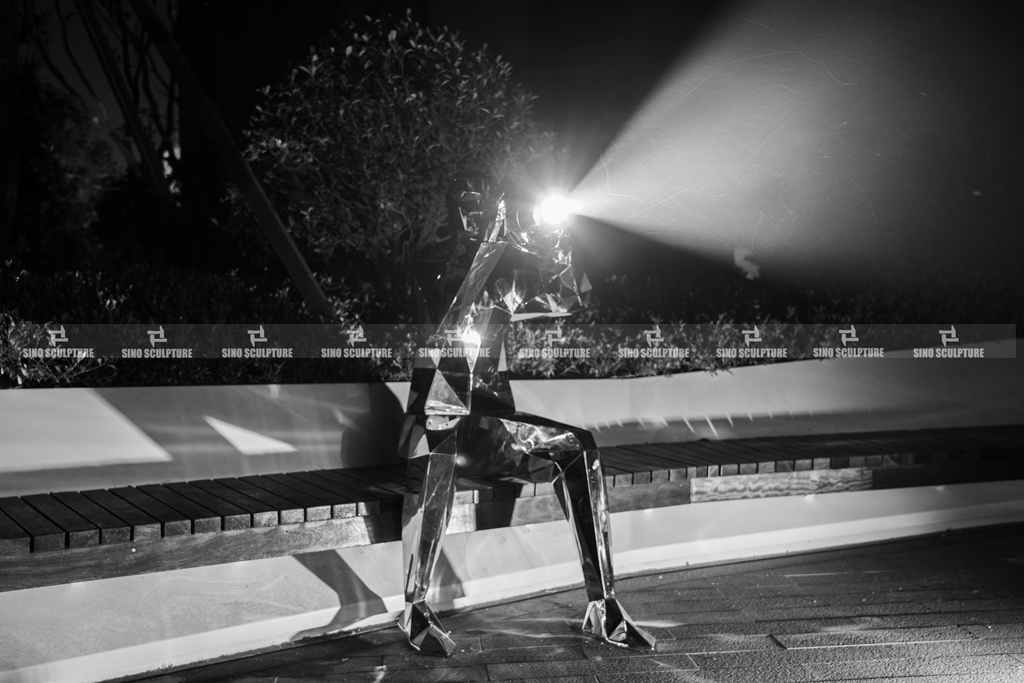 Night view of the mirror steel photographer statue 