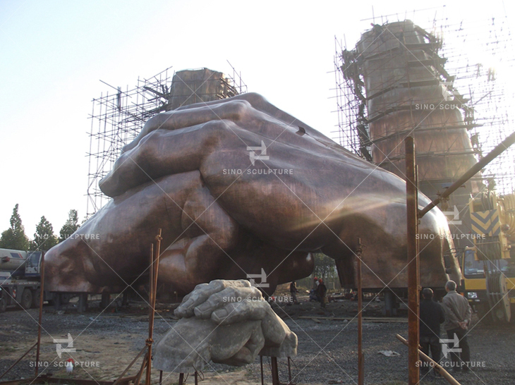 Bronze monumental sculpture sections lifting and assembling at site.