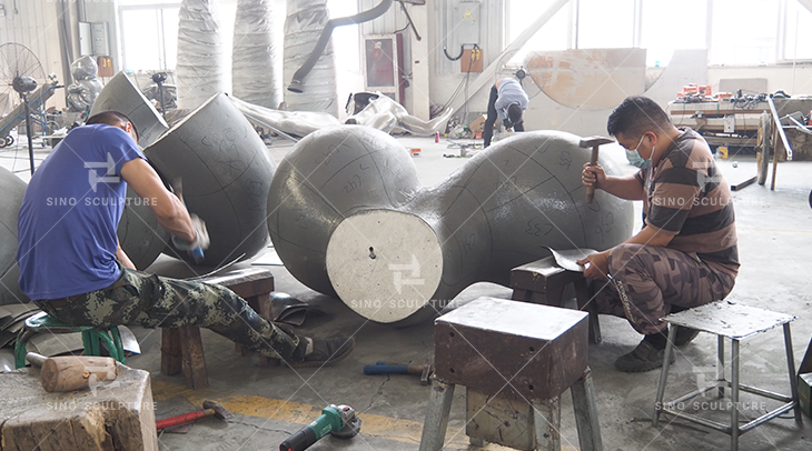 Hand forging the stainless steel panels on the hard foam model