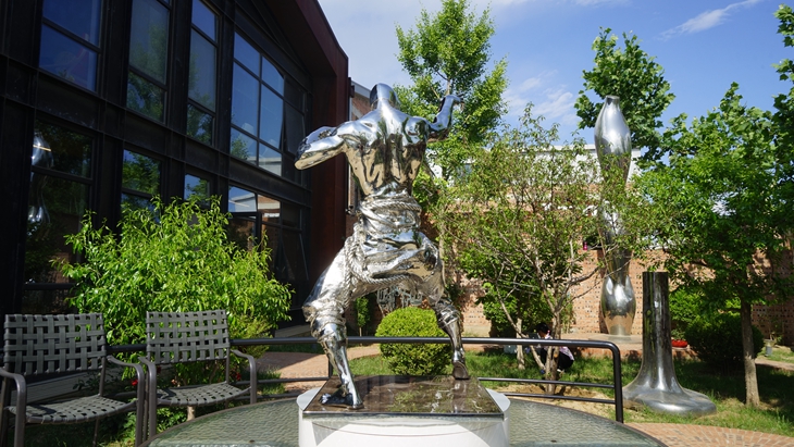 Backside of the vivid ancient warrior statue in mirror stainless steel