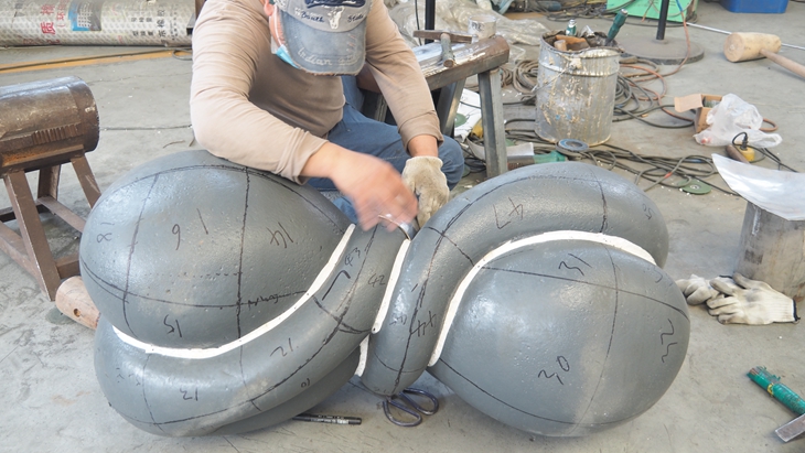 Hand forging of the steel panels on the model of the Twisted sculpture